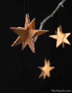 three wooden stars hanging from strings in the dark