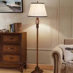 a lamp that is on top of a wooden table next to a dresser and chair