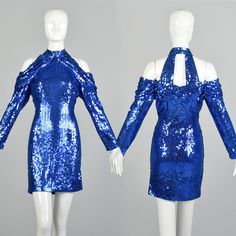 "Description: Stunning cobalt blue sequin party dress has a unique cold shoulder design, long sleeve and high collar. Body hugging, curvy! Let's dance! Condition: Very Good Condition Details: The sequins have minor color loss here and there. Size Marked: Small Approximate Size: Small- Medium **Please Check Measurements to be Sure! Textile: 100% Polyester Lining Type: Unlined Closure: Back Nylon Zip Label: Daval Designs Era: 1990s Measurements- Shoulder to Cuff: 19.5\" Chest/Bust: 34\"-36' Waist: Blue Fitted Mini Sequin Dress, Blue Mini Dress With Contrast Sequins, Glamorous Blue Off-shoulder Mini Dress, Blue Fitted Sequin Fabric, Off-the-shoulder Cutout Sequined Slim-fit Mini Evening Dress, Sequin Party, Sequin Party Dress, Let's Dance, Body Dress