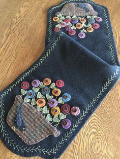 two pieces of blue fabric with flowers on them sitting on top of a wooden floor