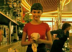 a woman standing in front of a counter holding a piece of paper