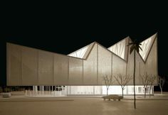 the building is lit up at night with palm trees in front of it and on the ground