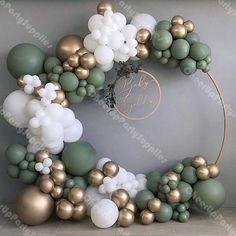 the balloon arch is decorated with gold, white and green balloons