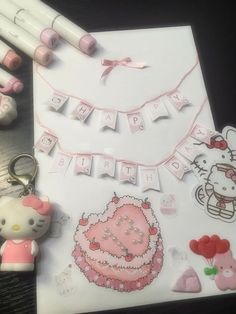 a hello kitty themed birthday card and keychain on a table with other items