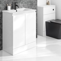 a bathroom with a toilet, sink and cabinet next to each other in black and white