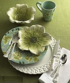 a green place setting with flowers and silverware