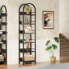 a living room filled with furniture and a book shelf next to a plant on top of a hard wood floor