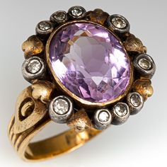 This captivating vintage 19K yellow gold ring is centered with one (1), bezel set, oval mixed cut natural amethyst and is bordered with ten (10) old European/single cut diamonds set into sterling silver bezel setting. The shank has a fluted design and is stamped 19K. The ring measures 17.2mm at the top, rises 6.9mm above the finger, tapering to 3.1mm wide and 0.9mm thick at the base of the shank. This ring is currently a size 7.25. Heirloom Amethyst Ring In Yellow Gold With Bezel Setting, Luxury Gold Amethyst Ring With Rose Cut Diamonds, Oval Amethyst Ring With Bezel Setting For Formal Occasions, Luxury Yellow Gold Amethyst Ring With Rose Cut Diamonds, Heirloom Purple Ring With Rose Cut Diamonds, Formal Rose Cut Amethyst Ring In Yellow Gold, Vintage Gemstone Accent Rings For Anniversary, Formal Gold Amethyst Ring With Rose Cut Diamonds, Formal Yellow Gold Amethyst Ring With Rose Cut Diamonds