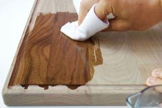 someone using a cloth to clean the wood grains on a piece of plywood