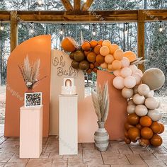 an outdoor display with balloons and decorations for a baby's first birthday or party