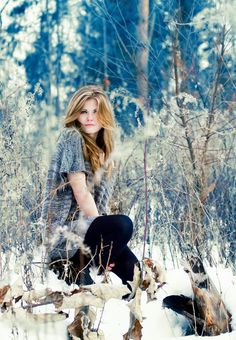 a woman sitting in the snow with her legs crossed