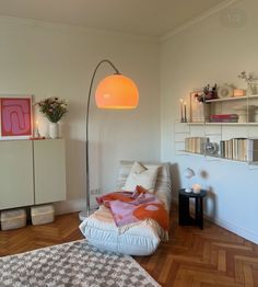 a bedroom with a bed, lamp and bookshelf on the wall behind it