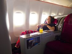 a woman is sitting on an airplane with her head down