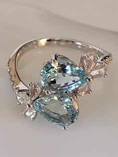 You are purchasing a CJ Jeweler 14K White Gold Aquamarine Diamond Cocktail Rig. This gorgeous ring is crafted in 14k white gold and features 2 sparkling eye clean faceted pear aquamarines, accompanied by 6 pear diamonds set in crossover flower motif and there're additional 10 round brilliant diamonds bezel set on the band. Each aquamarine measures about 9x7mm and each pear diamond is 4x2mm. The total weight of the gemstones is about 3.93 carats. The face of the ring is about 20x15mm the band wid Aquamarine Cocktail Ring, Sparkling Eyes, Diamond Cocktail Ring, Gorgeous Ring, Diamond Cocktail Rings, Flower Motif, Aqua Marine, Old Jewelry, Pear Diamond