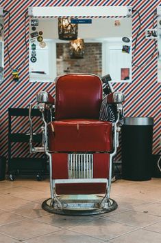 a red chair sitting in front of a mirror