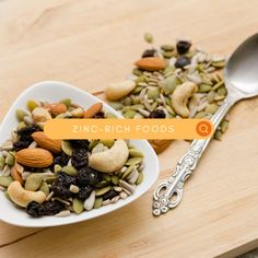 a white bowl filled with nuts and raisins on top of a wooden table