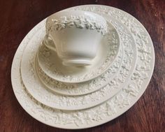 a stack of white plates sitting on top of a wooden table