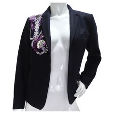 Introducing the exquisite Dries Van Noten Navy Crystal Embroidered Blazer, a timeless and luxurious piece that exudes sophistication and style. Crafted from classic navy fabric, this blazer features a whimsical paisley embroidery on the right shoulder, creating a bold and stunning detail that sets it apart from the rest. The paisley embroidery is adorned with metallic silver and purple beading, adding a touch of shimmer and elegance to the design. These beautiful colors complement the navy fabri Tailored Embellished Blazer For Work, Designer Embellished Tailored Blazer, Designer Tailored Embellished Blazer, Designer Semi-formal Embellished Blazer, Luxury Formal Outerwear With Floral Embroidery, Luxury Floral Embroidery Formal Outerwear, Luxury Floral Embroidered Formal Outerwear, Tailored Embellished Blazer For Semi-formal Occasions, Semi-formal Embellished Long Sleeve Blazer