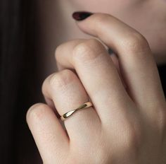 a close up of a person wearing a gold ring