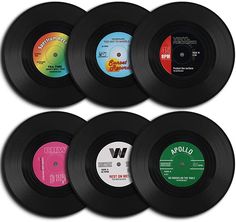 six different colored vinyl records are arranged in a row and one is black, the other is white