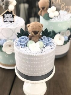 two small cakes with teddy bears on top, one is blue and the other is white