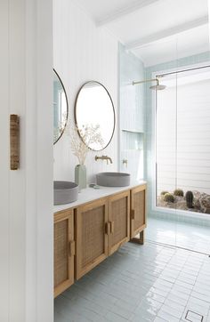 a bathroom with two sinks and mirrors on the wall