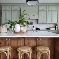 three stools sit at the center of a kitchen island