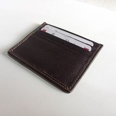 A leather cardholder is a small, compact wallet designed to hold just the essentials, typically credit cards, ID cards, and some cash. They are often made of genuine leather, providing durability and style. Leather cardholders are typically smaller in size than traditional wallets, making them a convenient option for those who prefer to carry just the essentials. They come in a range of colors, sizes, and designs, and are perfect for those who want to streamline their carry. Small and compact de Brown Business Card Holder With Id Window, Classic Leather Coin Purse With Card Slots, Brown Business Card Holder With Interior Slots, Leather Rectangular Card Holder With Card Slots, Classic Brown Card Holder With Card Slots, Classic Brown Card Holder With Slots, Leather Card Holder With Slots As Gift, Classic Card Holder With Interior Slots For Gift, Classic Card Holder With Slots As Gift