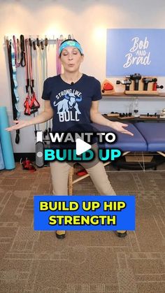 a woman standing in front of a wall with her arms out and the words build up strength