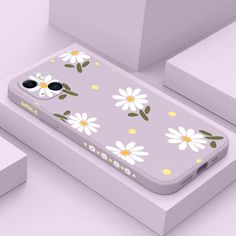 an iphone case with daisies and leaves is shown on top of a white box