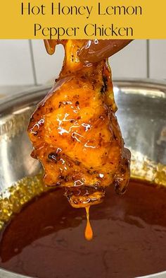 hot honey lemon pepper chicken is being lifted from a pot with sauce on it and the words, hot honey lemon pepper chicken