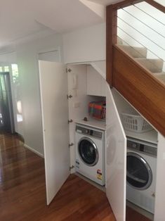 a washer and dryer in a room with wood flooring on the ground