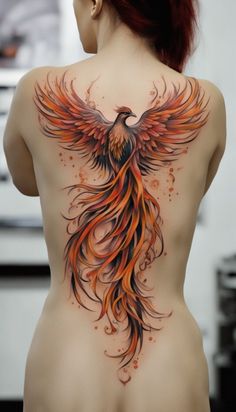 the back of a woman's body with an orange and black bird tattoo on it