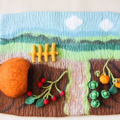 an orange and some vegetables on top of a piece of felt