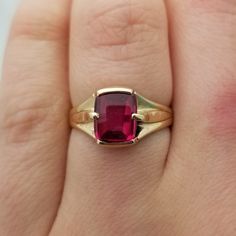 Very unique and very old, this style of ring and synthetic ruby were hot in the 1940s! This one is a 1.5 carat ruby cabochon elongated cushion cut stone in a half bezel, half prong setting. It looks great on both men and women.  - Stone is 7.8 x 6.9mm - 2.49mm band - Half bezel, half prong set - Ring is almost 100 years old - 3.61g total weight  - So retro! - Size 7.25 Classic Ruby Ring With Rectangular Polished Finish, Classic Ruby Ring With Polished Rectangular Finish, Classic Rectangular Ruby Ring With Polished Finish, Formal Ruby Signet Ring In Fine Jewelry Style, Classic Ruby Ring With Polished Lab-created Ruby, Ruby Signet Ring Fine Jewelry For Formal Events, Fine Jewelry Ruby Signet Ring For Formal Occasions, Heirloom Ruby Signet Ring With Polished Finish, Ruby Signet Ring For Formal Occasions