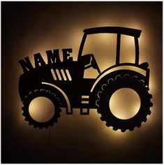 a tractor silhouetted against a wall with the word name on it's front