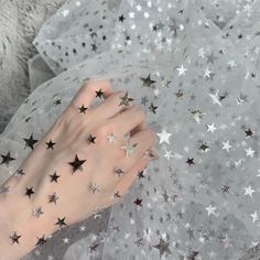 a woman's hand with stars painted on her body and white mesh net fabric