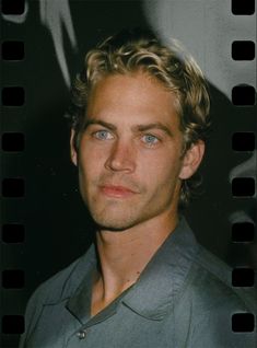 a man with blonde hair and blue eyes is posing for a photo in front of a film strip