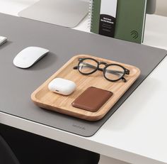 a wooden tray with glasses, mouse and book on it