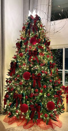 a decorated christmas tree with red and green bows