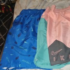 Nwt Nike Swim Shorts Bundle One Pair Blue With Just Do It Written All Over Other Pair Pink And Green With Nike Written In Pink Size Is Xl Nike Beachwear Shorts For Swimming, Nike Beach Shorts With Elastic Waistband, Nike Shorts With Elastic Waistband For Beach, Nike Beach Shorts With Pockets, Nike Vacation Shorts, Nike Shorts With Pockets For The Beach, Nike Casual Vacation Bottoms, Sporty Nike Bottoms For Vacation, Nike Swim Trunks With Built-in Shorts For Beach