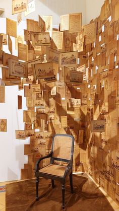 a chair sitting in front of a wall made out of wooden blocks with pictures on them