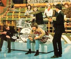 the rolling stones performing in front of an audience with their guitars and drums on stage