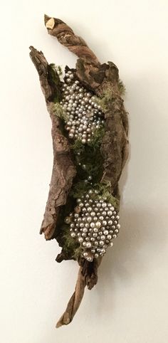 a piece of wood with white beads on it