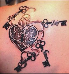 the back of a woman's shoulder with keys and a heart tattoo on it