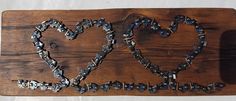 a wooden sign with two hearts made out of metal chains on it's sides