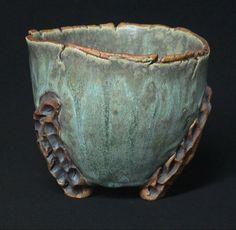 a close up of a bowl on a black surface with chains around it and an intricate design in the middle