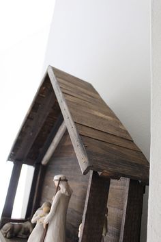 a small wooden birdhouse sitting on top of a shelf next to a white wall