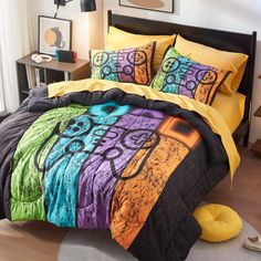 a bed covered in colorful comforters and pillows