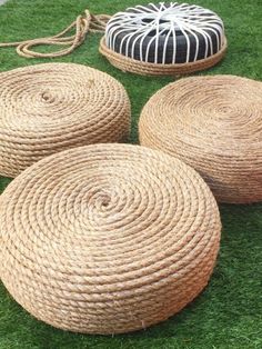 four round baskets sitting on top of green grass next to two black and white pillows